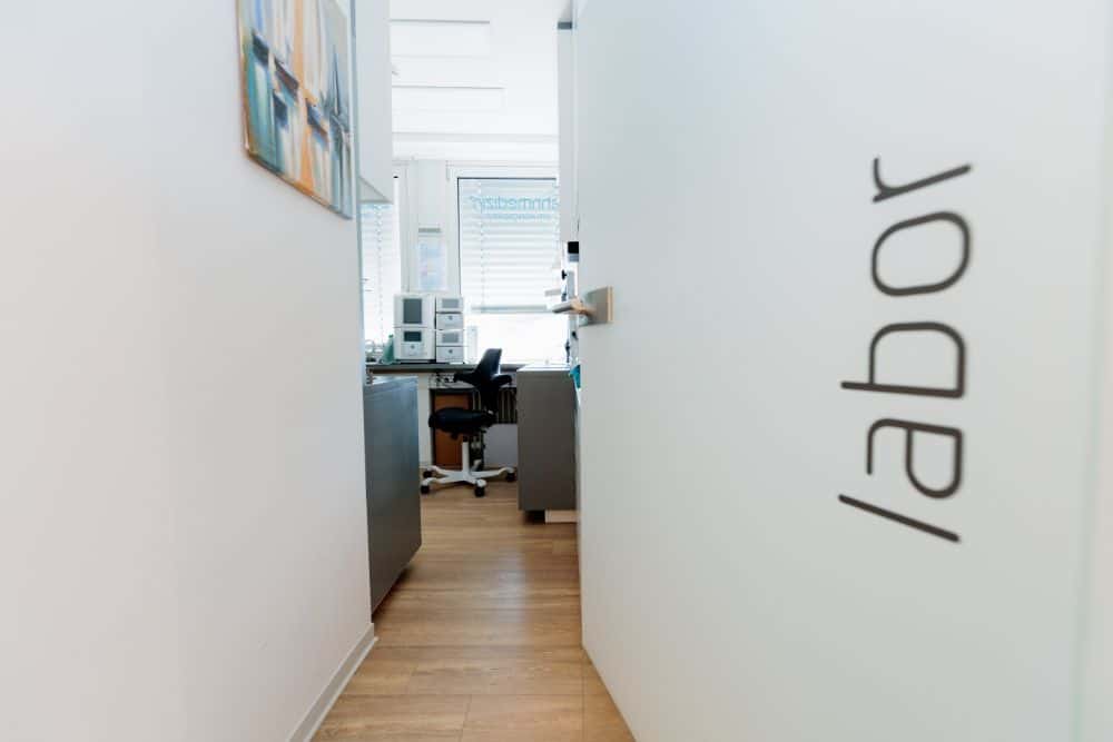 Ein Flur in einem Büro mit einem Schild mit der Aufschrift „Arbeit“ und „Zahnarzt Augsburg“.