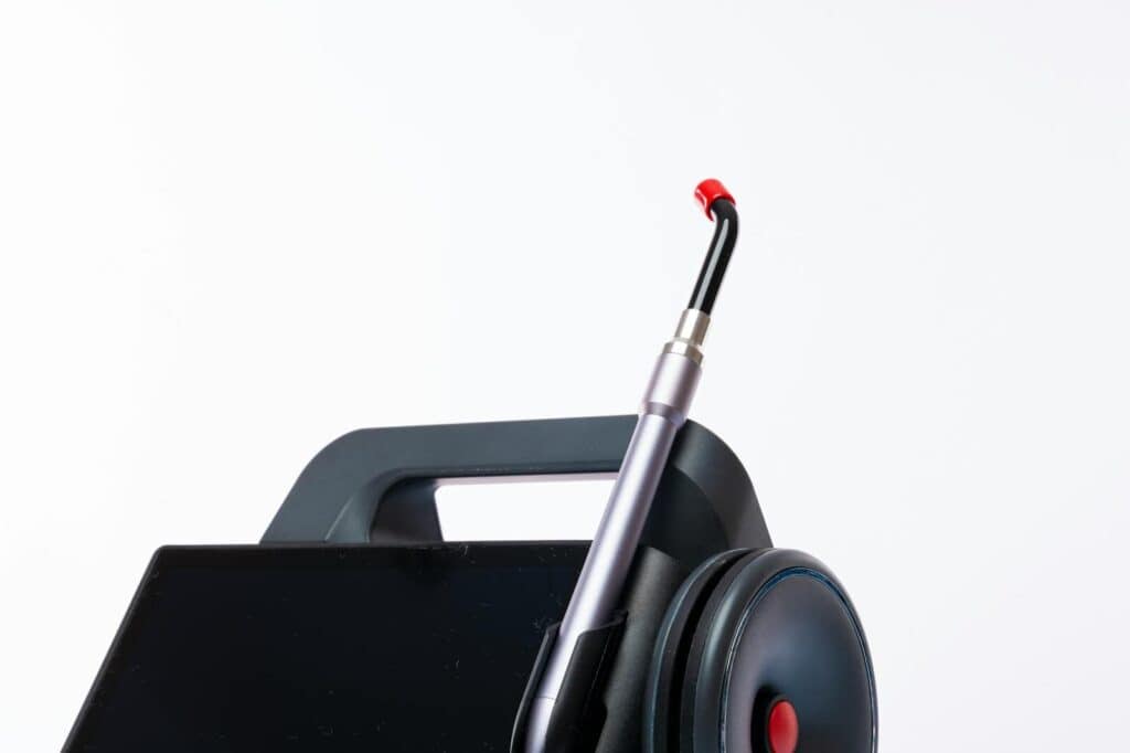 Close-up of a dental laser machine with a screen and handpiece, showcasing modern medical technology.